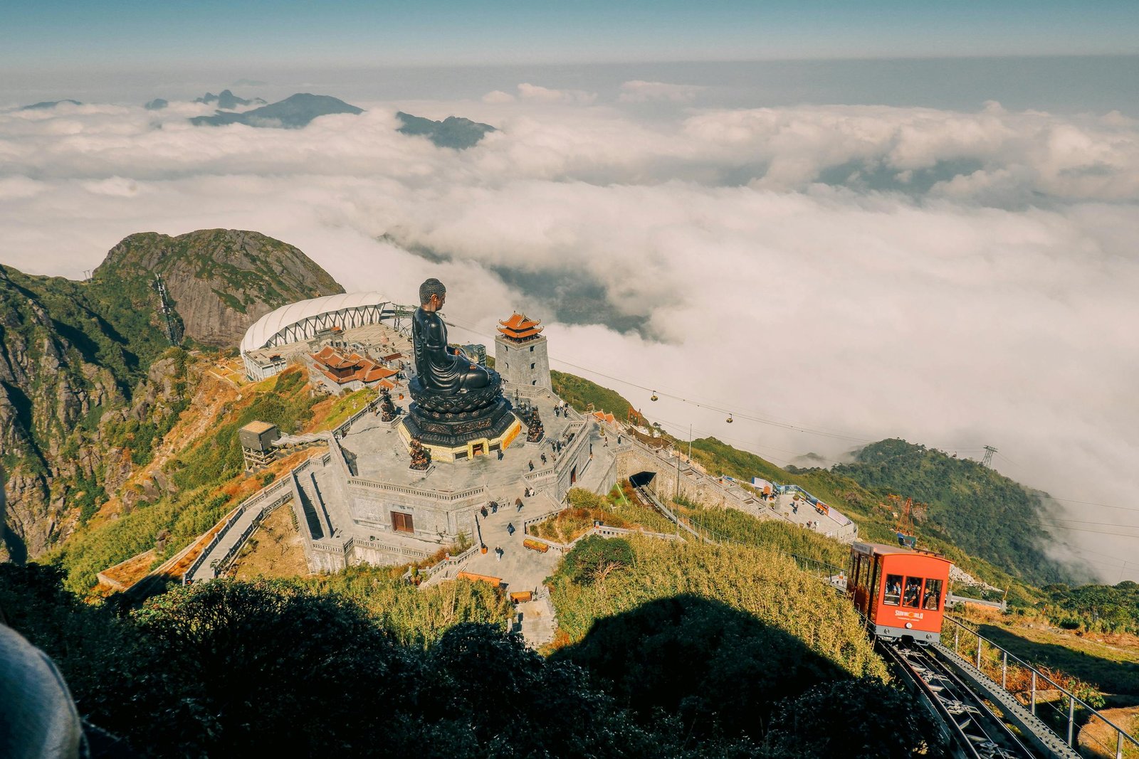 Aerial view of Fansipan Mountain in Lao Cai, Vietnam with a large Buddha statue and scenic cable car ride.